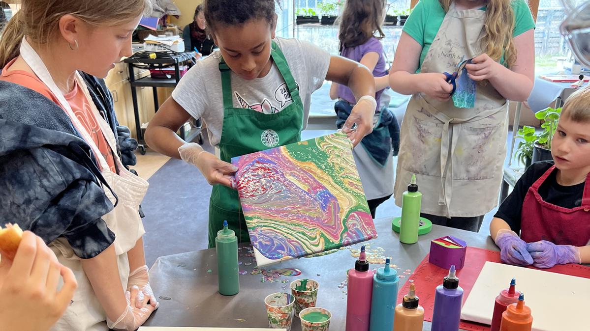 Elementary school students making art in a classroom. 